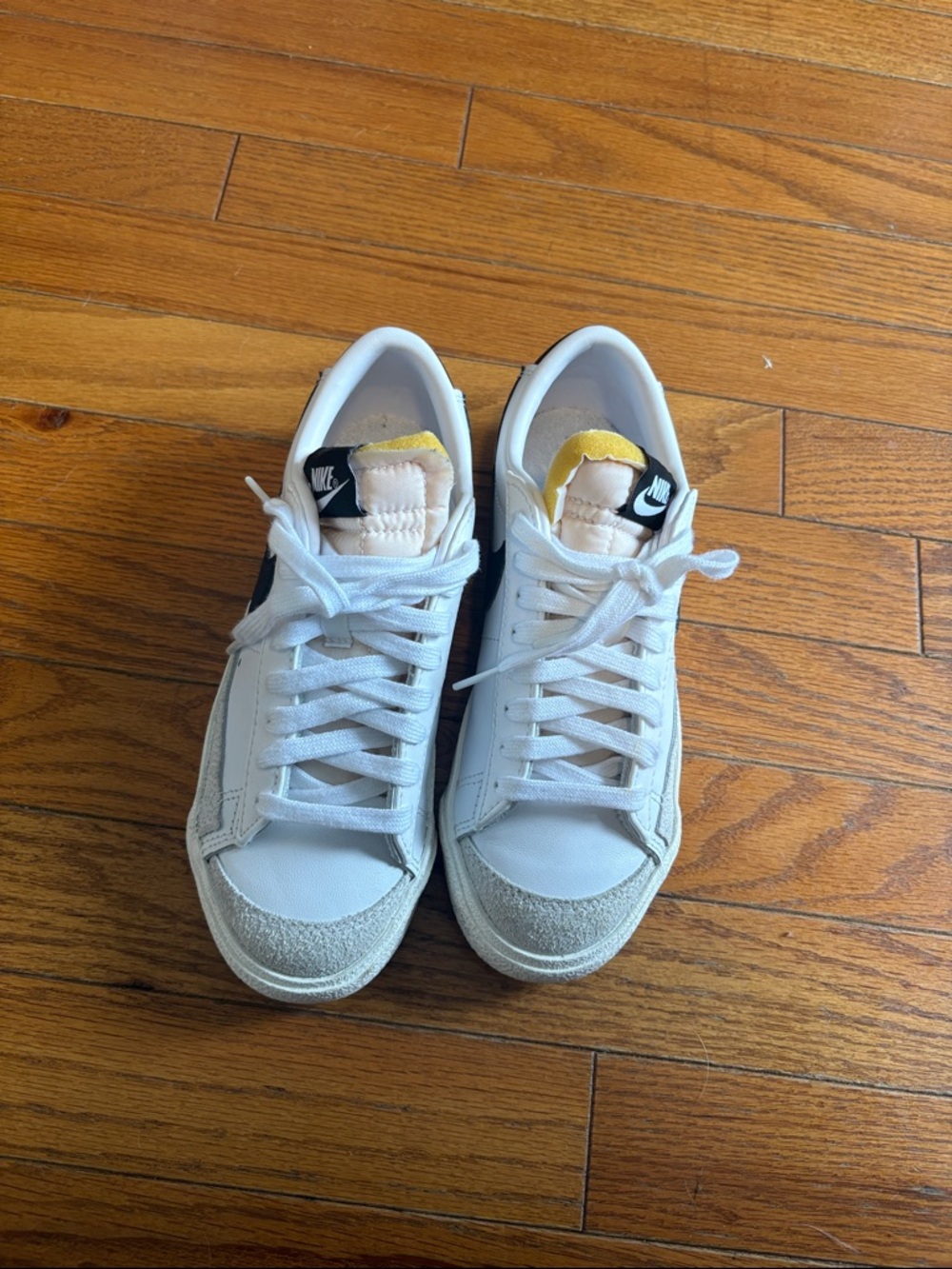 Nike Women's White Sneakers with Black Swoosh and Yellow Tongue Accent